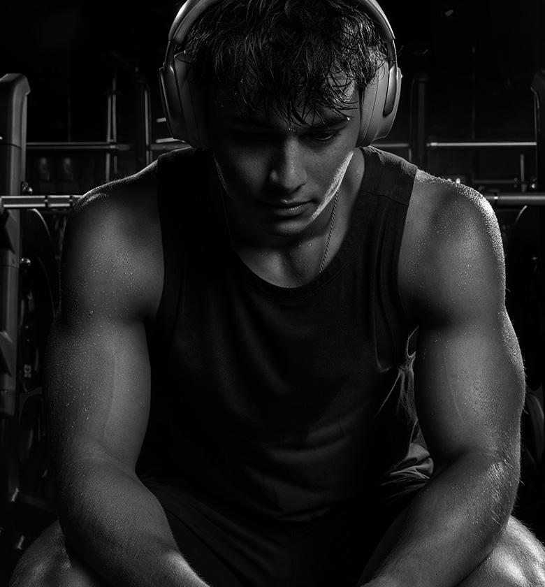 Member in headphones resting on a bench between sets