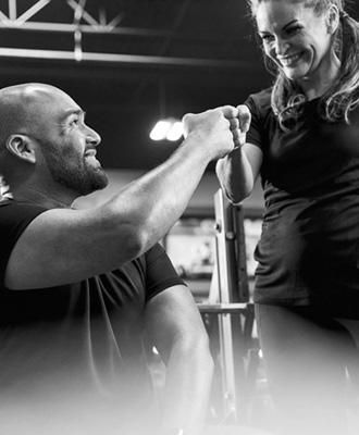 gym members smiling and fist bumping